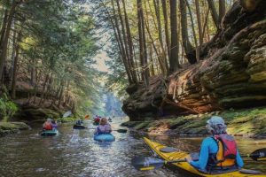 Photo of kayakers as they exist a high-walled gorge in the Dells. Photo by Patty Henry