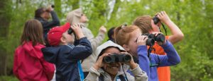 A group of kids looking through binoculars, banner image for the Great Wisconsin Birdathon webpage