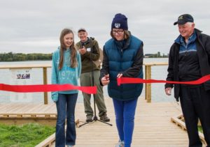 Woman cuts red ribbon at opening event