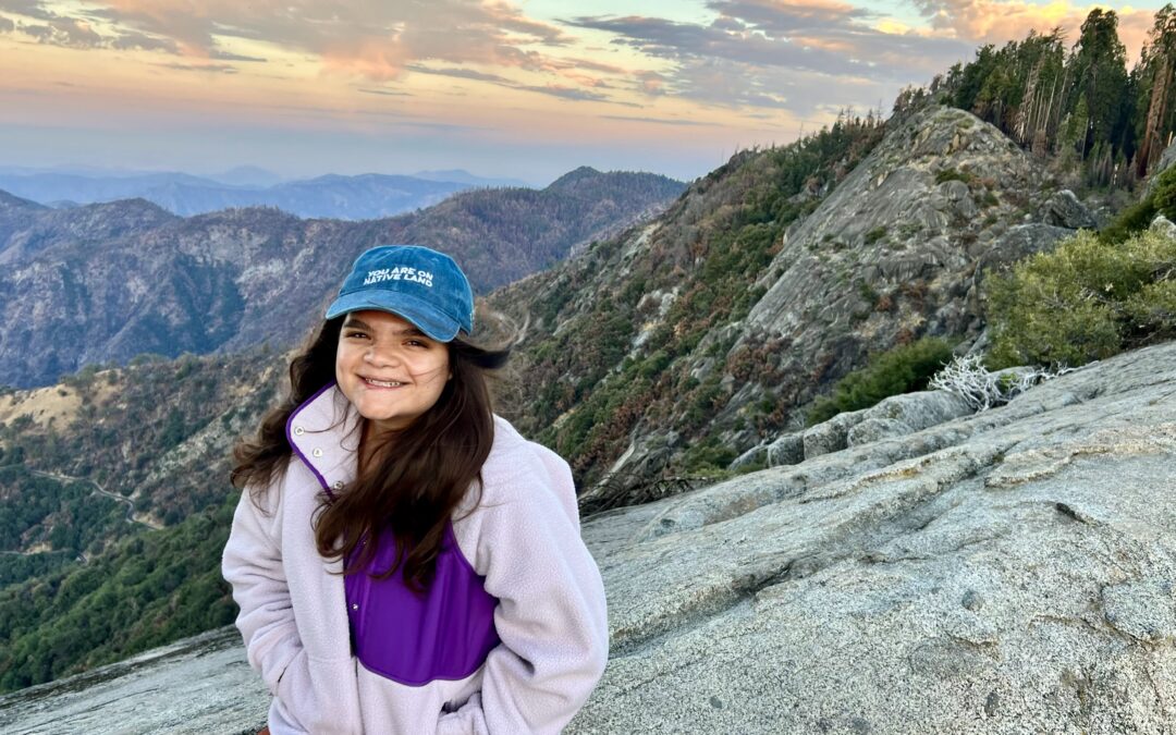 Emma sitting on a rock overlooking the sunrise on the Moro Rock trail in Sequoia National Park