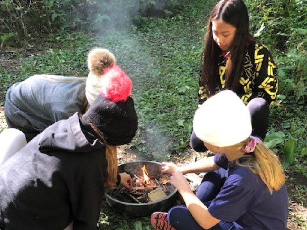 Blog post photo dimensions 43 (2) Students starting a campfire.