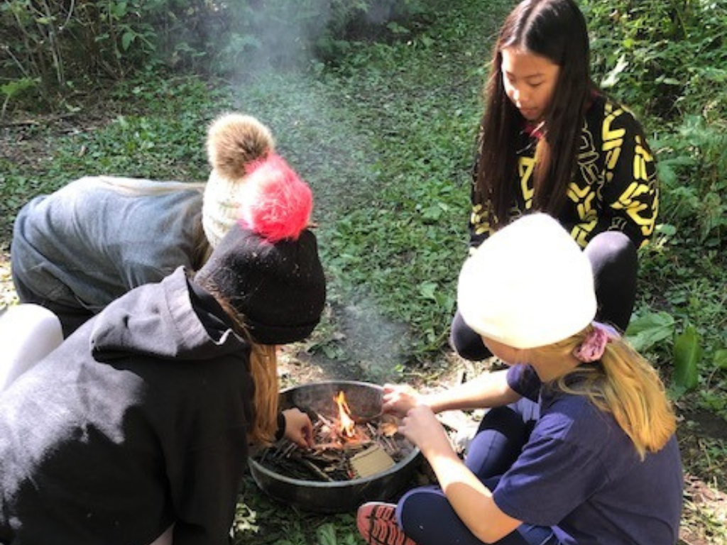 Students starting a campfire.