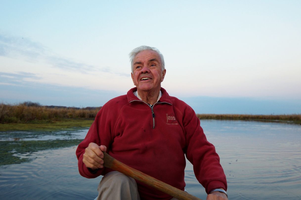 Cal Dewitt smiles and looks at the sky while canoeing