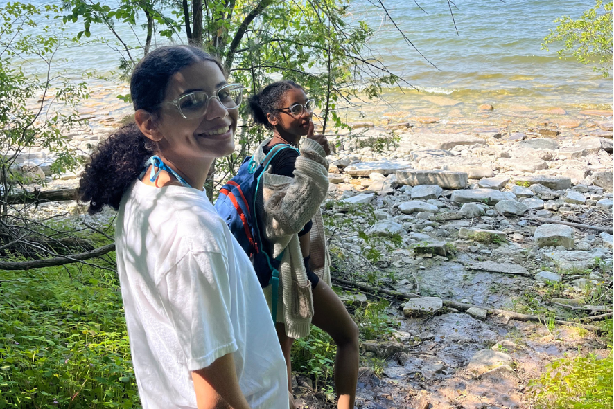Two Escuela Verde students on a hiking trail next to a body of water