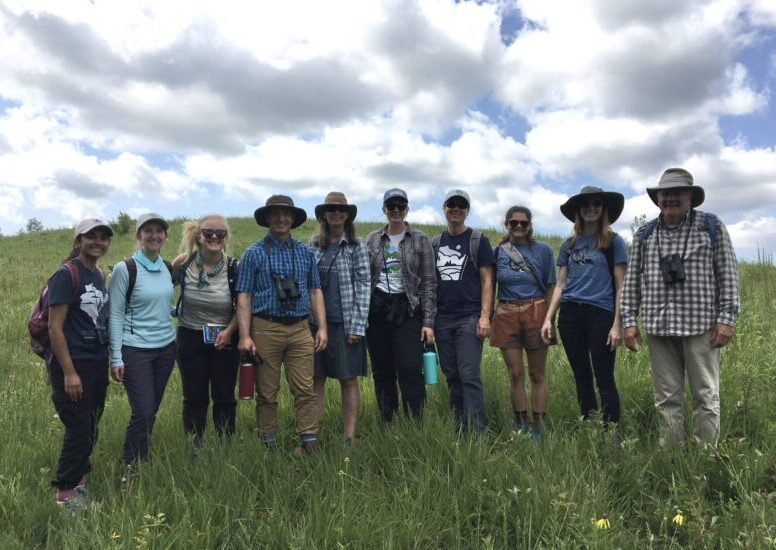 Nine NRF staff members standing in a prairie