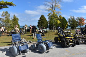Four outdoor wheelchairs on pavement during an outdoor wheelchair program at Point Beach