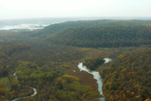 aerial view of a river running along a variety of landscape, including oak savanna, woodlands, and prairie